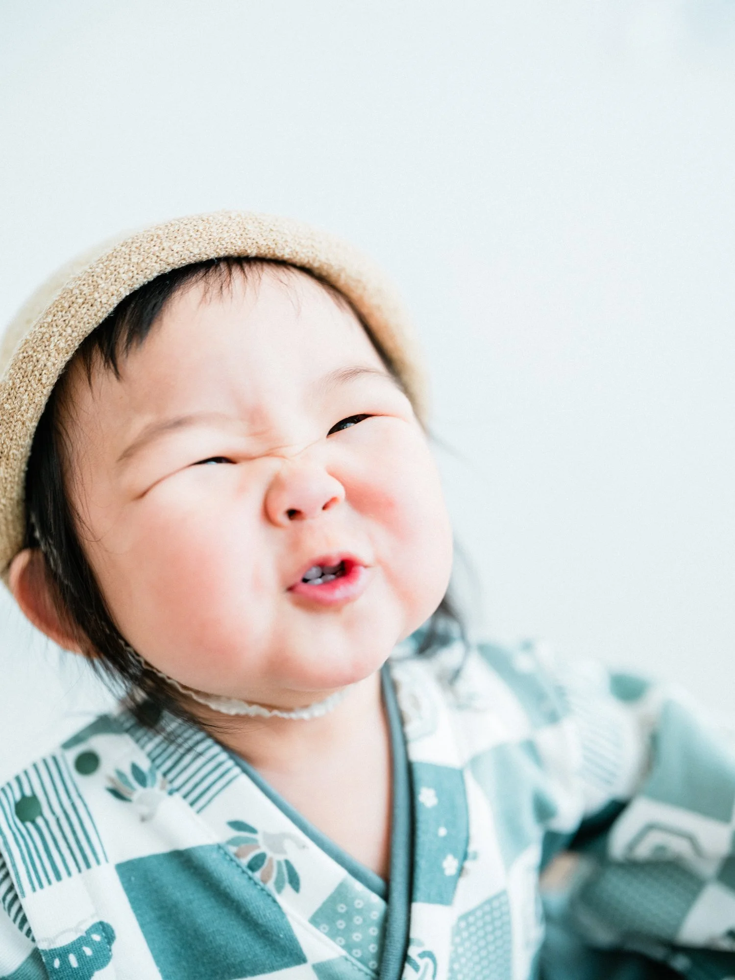 笑顔の幼い子供が帽子をかぶり、カメラを見ている。