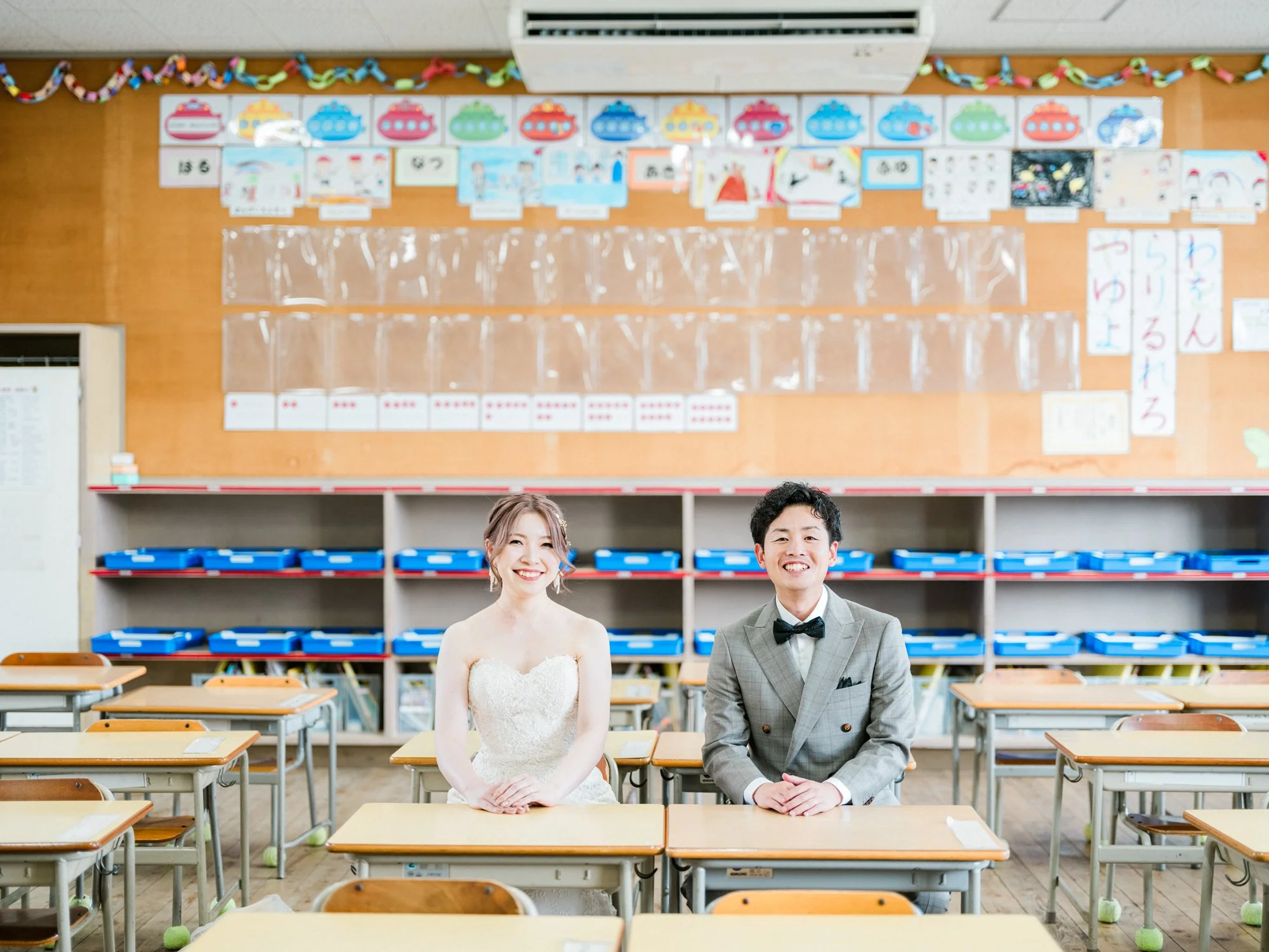 小学校の同級生。教室で笑顔の新郎新婦を写した写真。