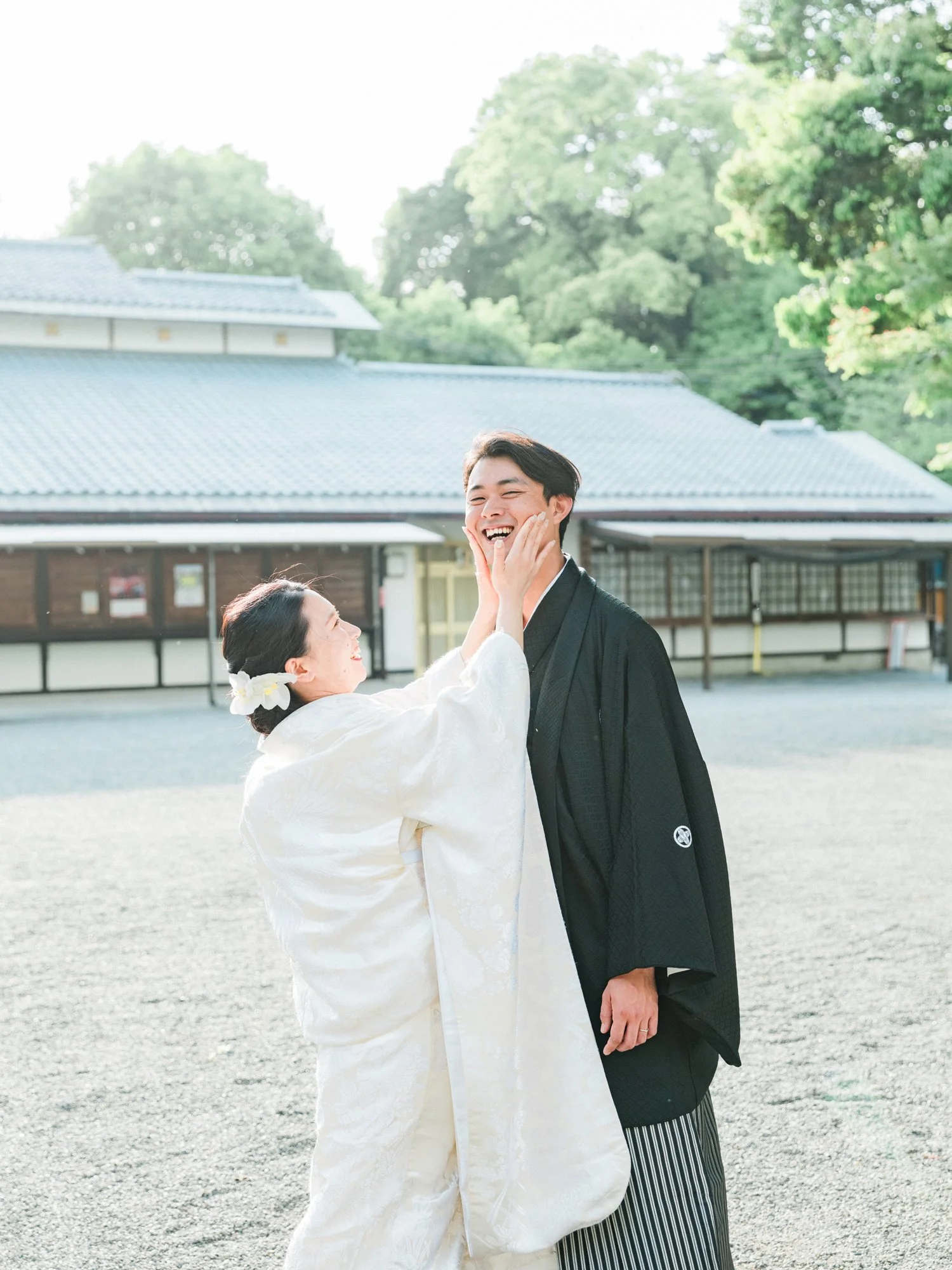 和服を着た女性が男性の顔を手で触れている幸せそうな大阪の歴史的な建物の庭園の前のシーン。