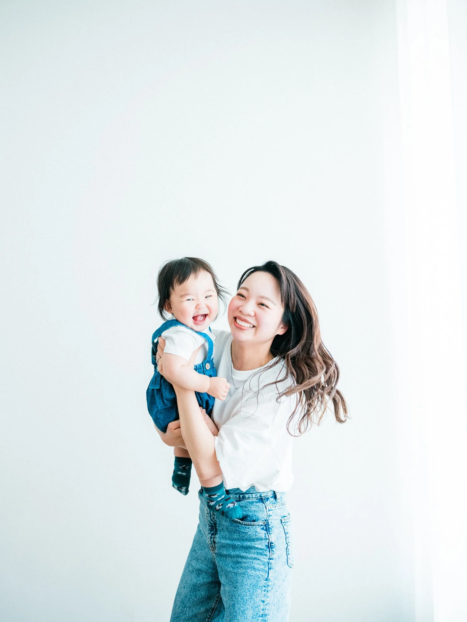 笑顔の女性が子供を抱きしめているバースデーの写真。