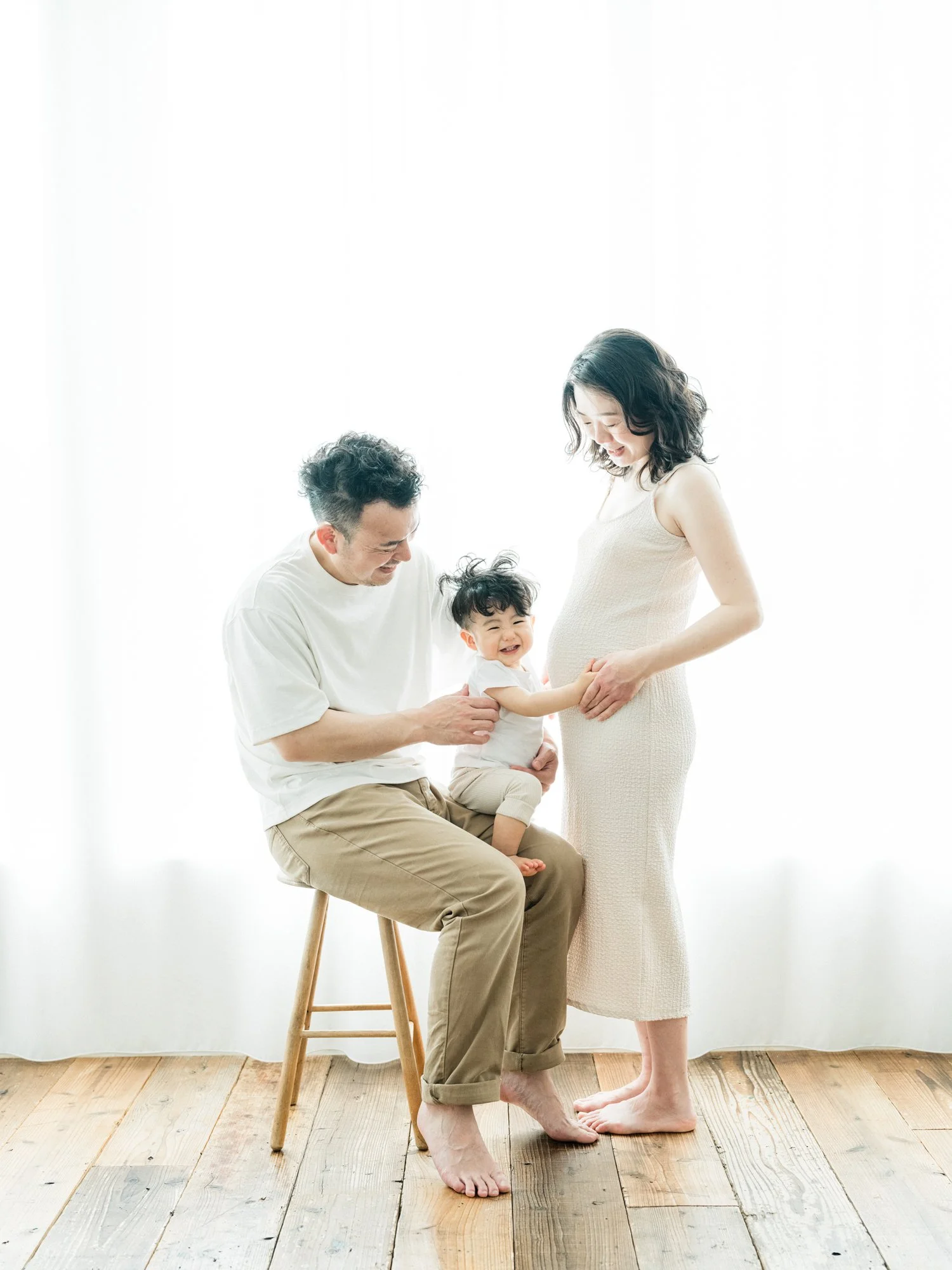 家族の写真：座っている男性と立っている女性、笑顔の子供がお互いを見ている温かい家庭の瞬間。