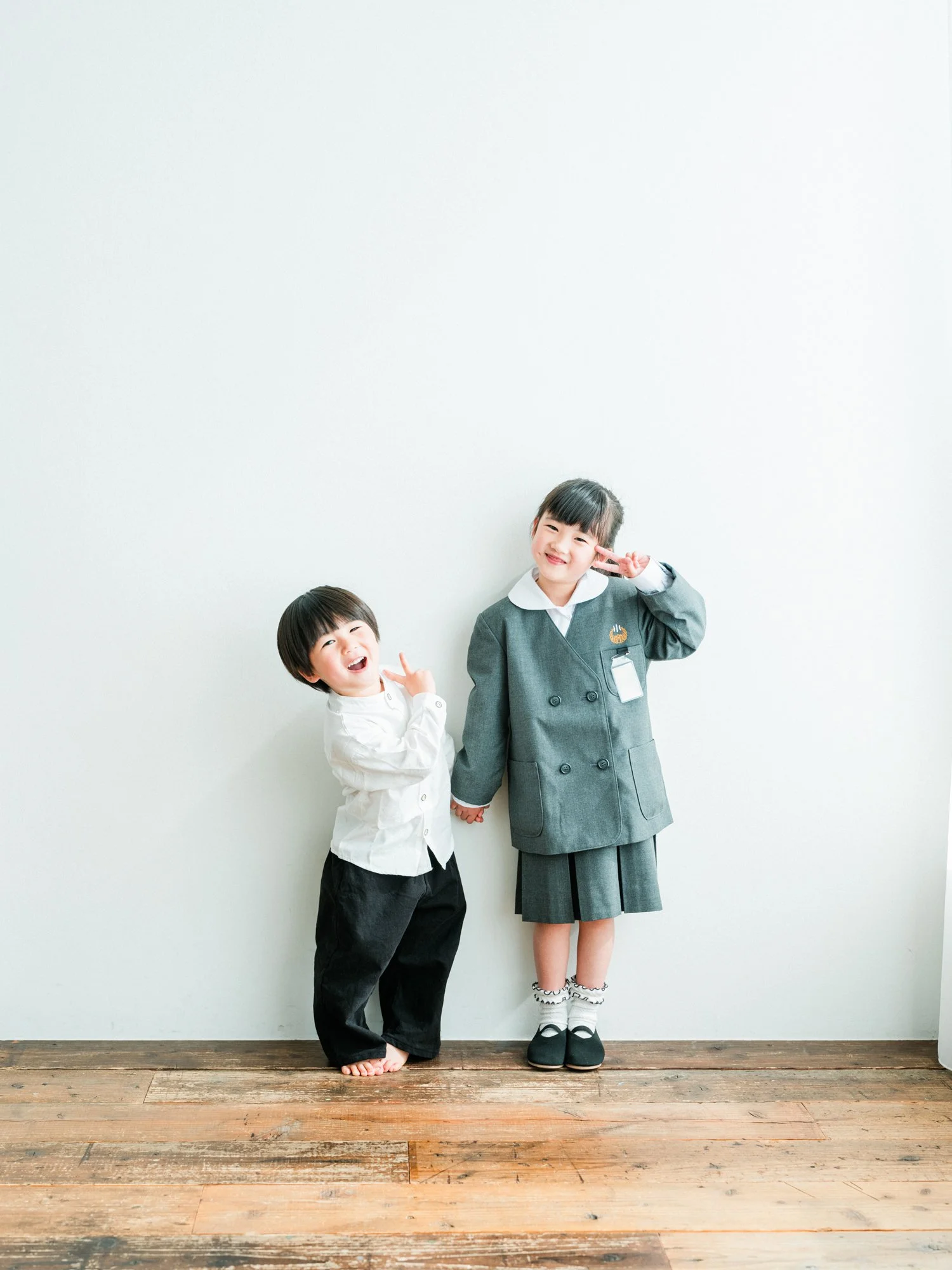 二人の子供が笑顔でカメラに向かってポーズをとっている。