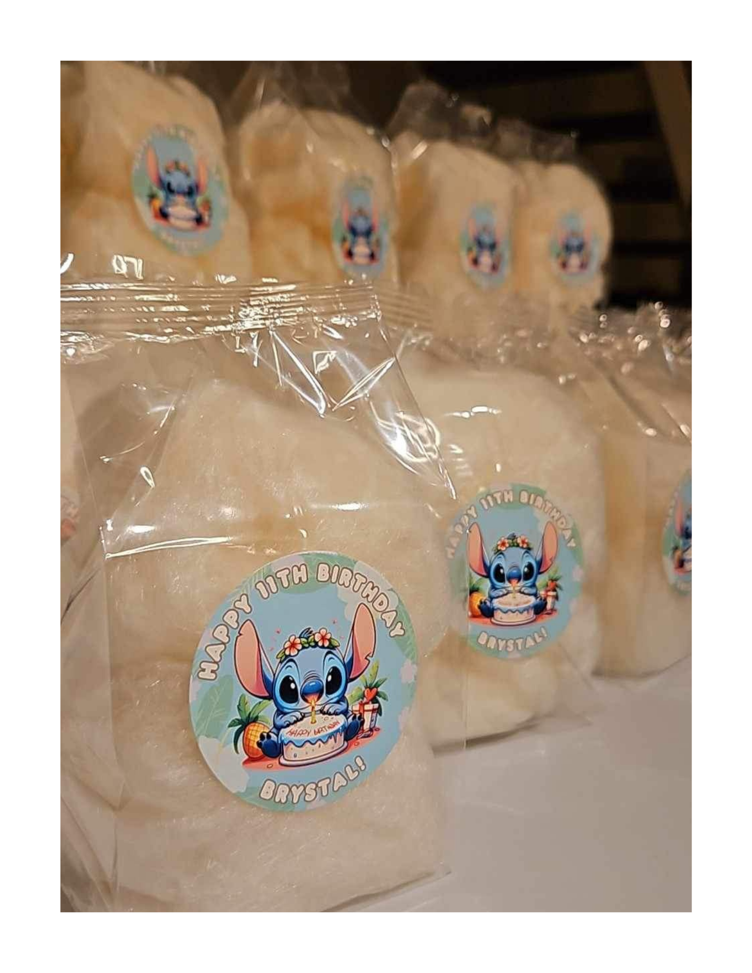 Clear plastic bags with stickers featuring a cartoon bunny celebrating a birthday in front of a cake with candles, surrounded by pumpkins and flowers, with text saying 'Happy Birthday. Roostar!'