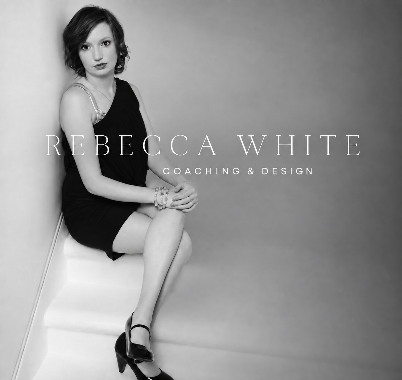 Black and white photo of a woman sitting on the floor in a corner, wearing a black dress and high heels, with text overlay that says 'Rebecca White Coaching & Design'.