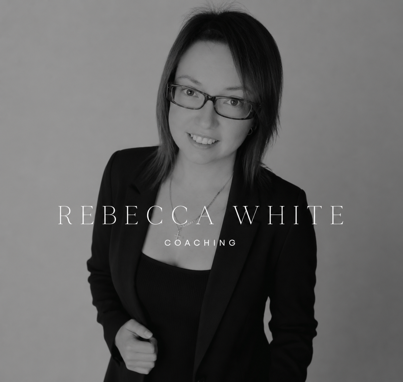 Black and white headshot of Rebecca White, a woman with shoulder-length hair and glasses, wearing a blazer and a necklace, smiling slightly, with her right hand clenched in a fist, against a plain background. The overlay text says "Rebecca White Coaching."