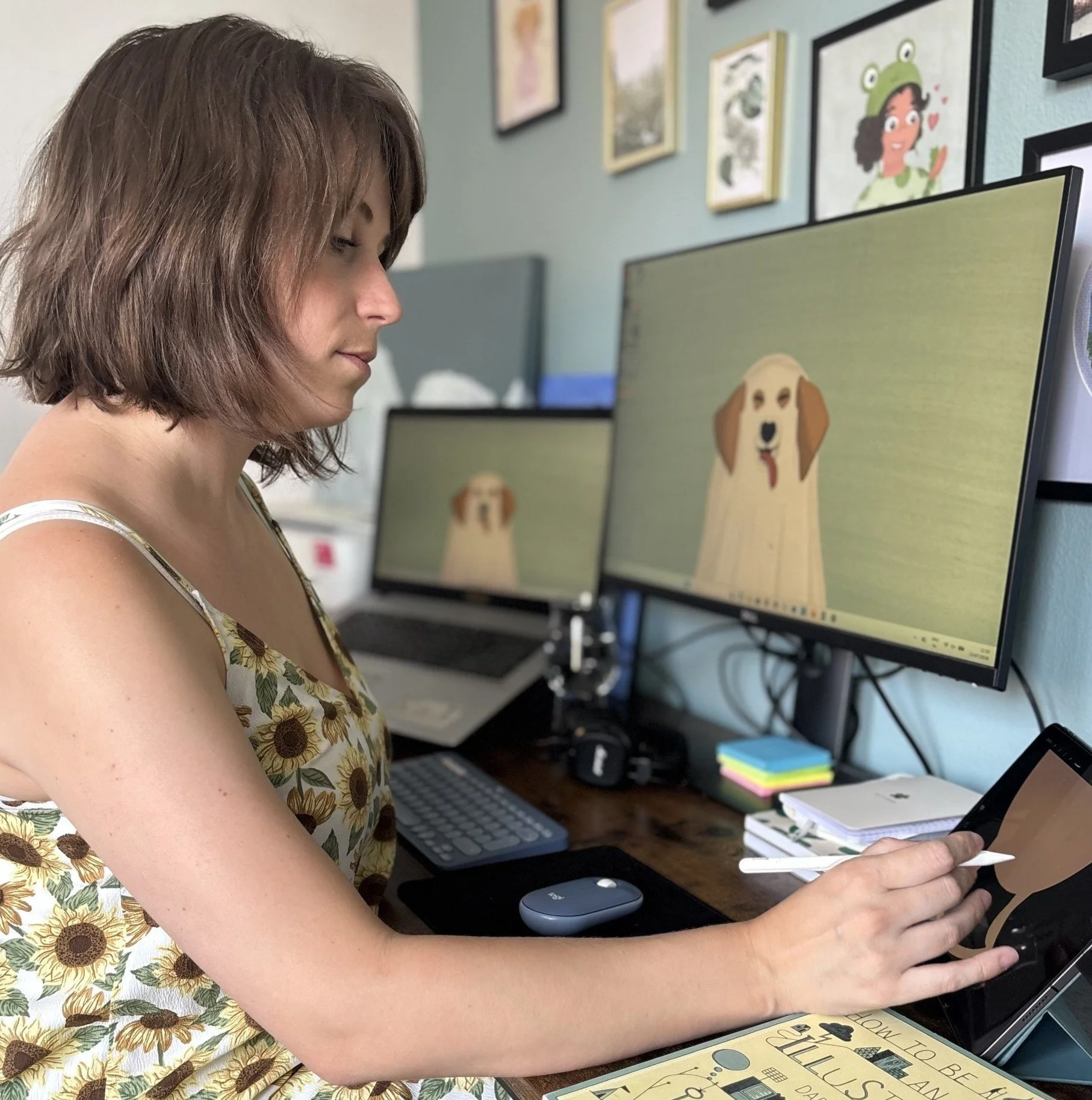 Photo of illustrator Sammy Godding drawing on her iPad behind her desk