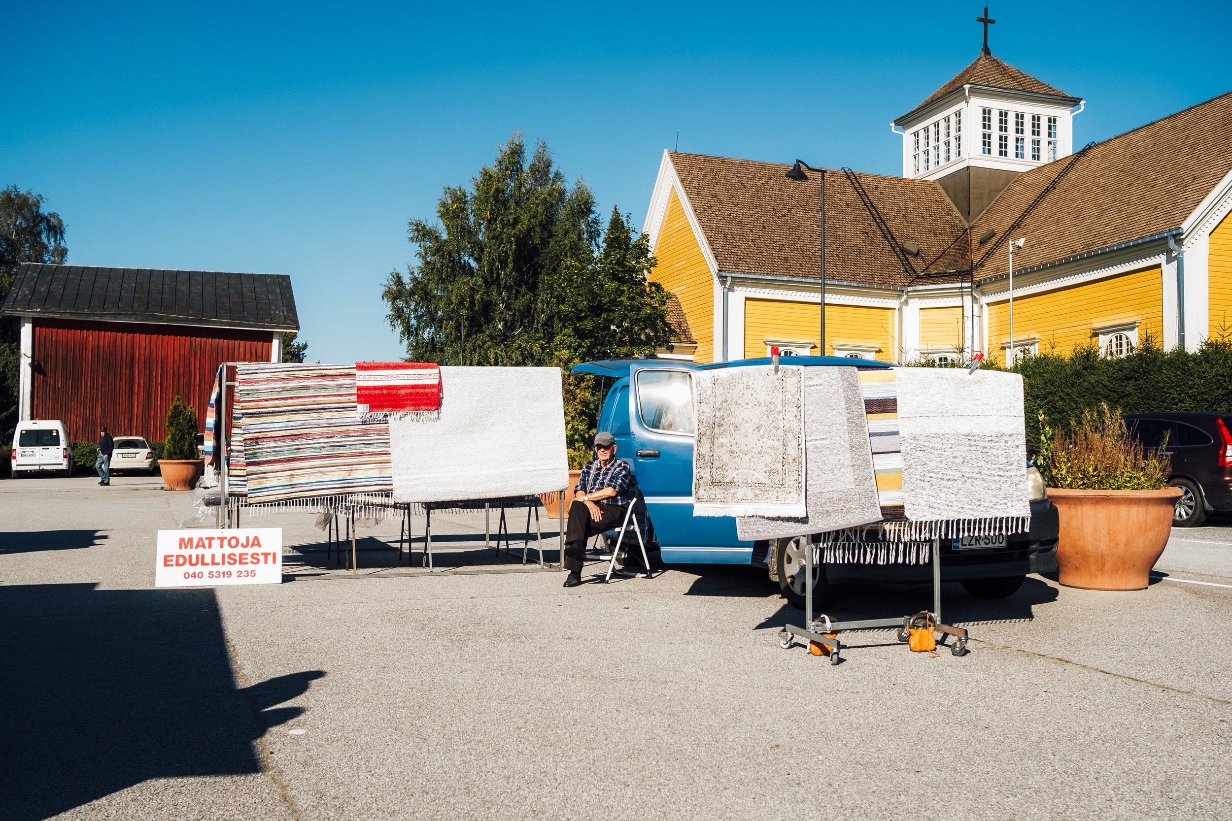 Vanha mies myy mattoja Ikaalisten torilla. Valokuvia Ikaalisista