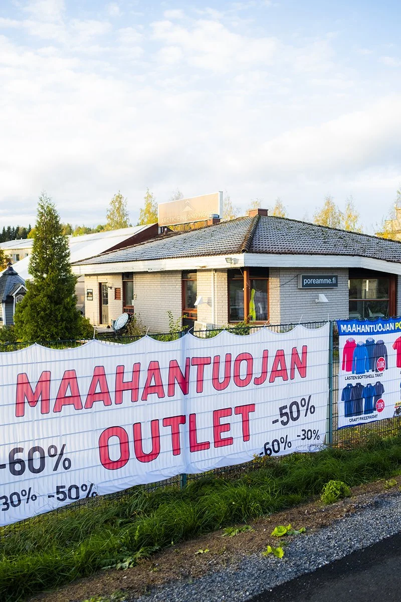 A sign outside a clothing store advertising a sale with discounts up to 60%.