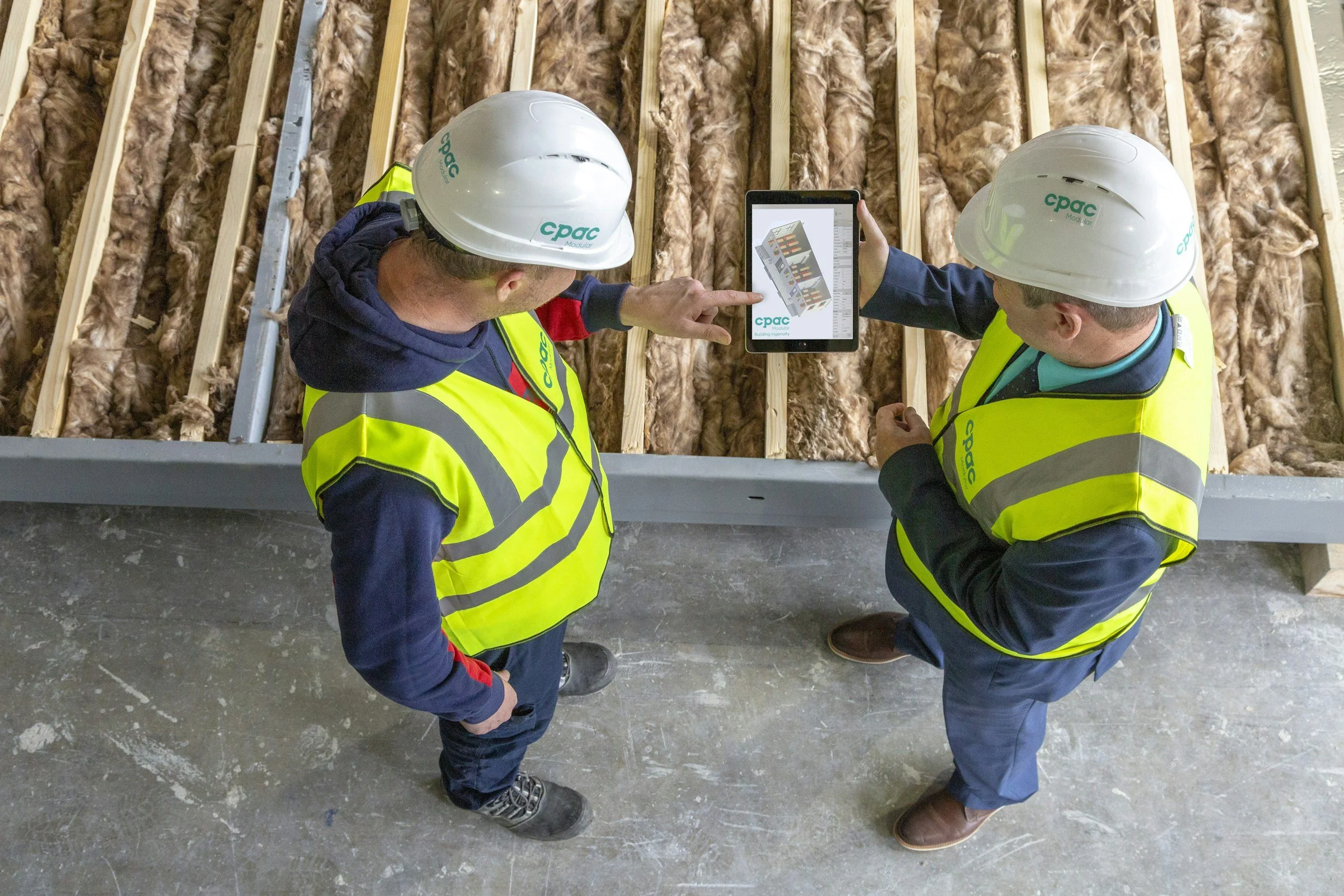 deux personnes qui échange concernant une pose d'isolation à partir d'un plan sur un chantier