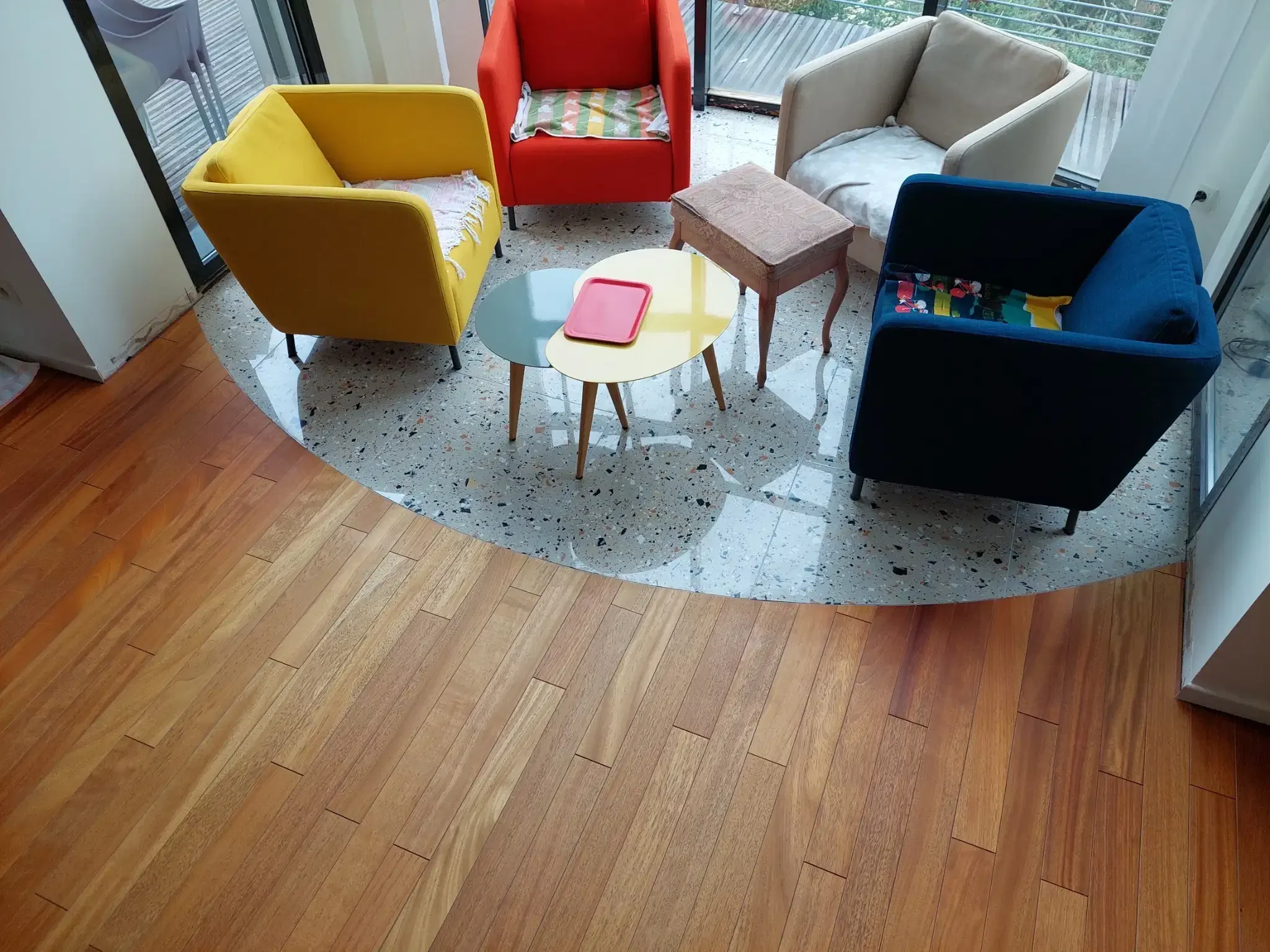 Rénovation de sol avec raccord arrondi entre parquet bois et carrelage terrazzo dans un séjour à Clermont-Ferrand
