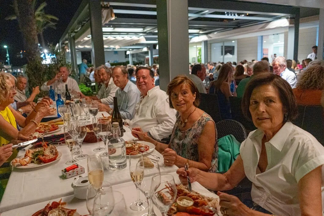 Grupo de personas cenando en un restaurante al aire libre por la noche.