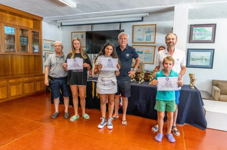 Un grupo de seis personas posando con certificados y trofeos en una sala, probablemente en una ceremonia de premiación o reconocimiento.