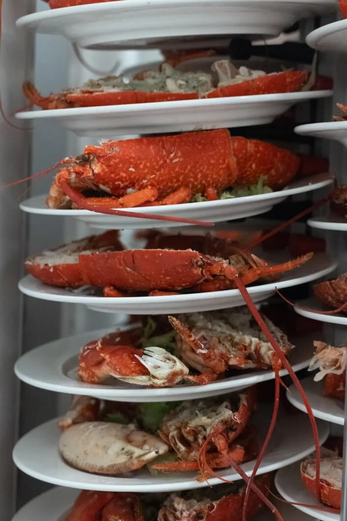 Marcian de platos con langosta cocida en exhibición en un refrigerador.