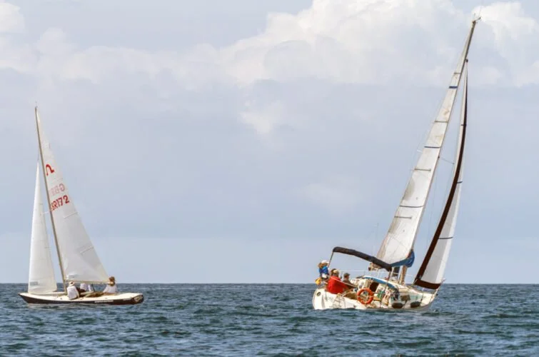 Dos veleros navegando en el mar bajo un cielo nublado.