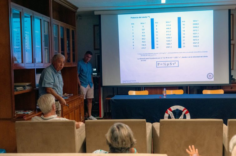 Reunión en un salón con una presentación sobre energía y viento en la pantalla.