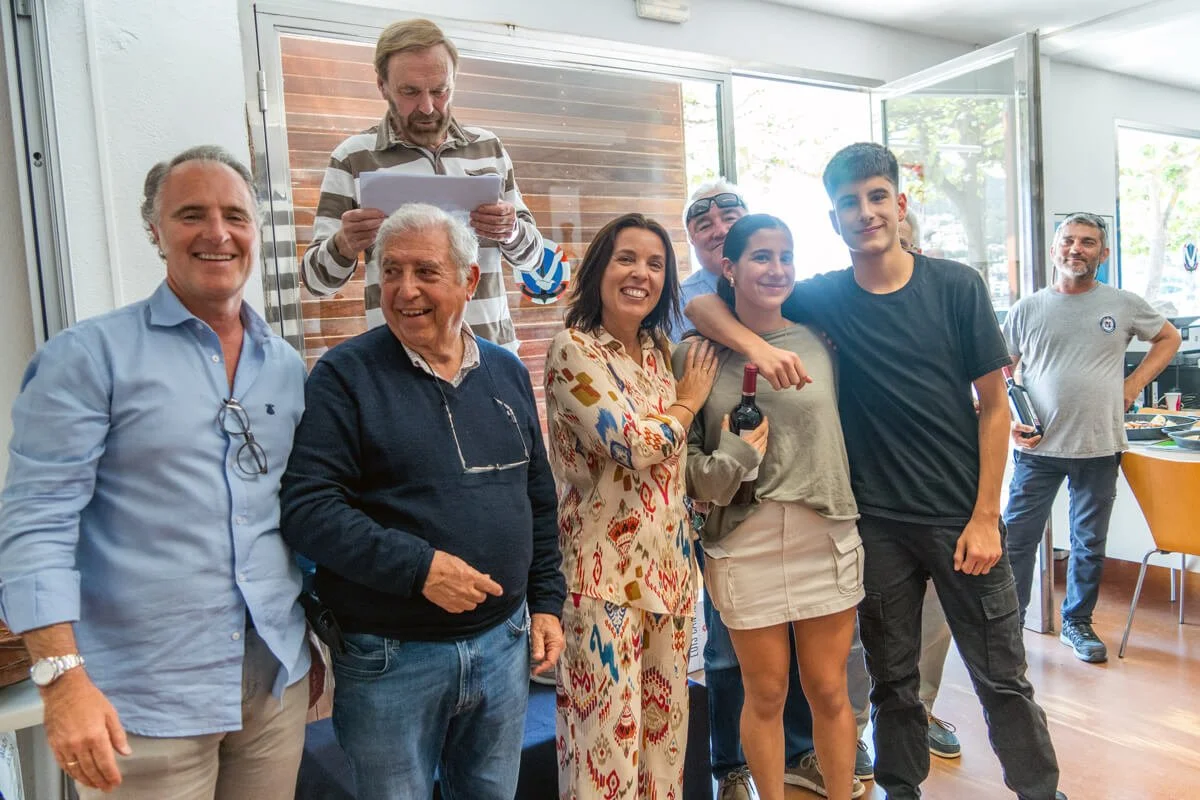 Grupo de personas celebrando en una reunión social en interiores con ventanas y luz natural.