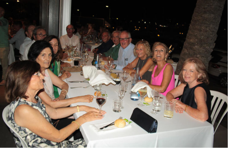 Grupo de personas sentadas en una mesa en un restaurante, disfrutando de una reunión social nocturna.