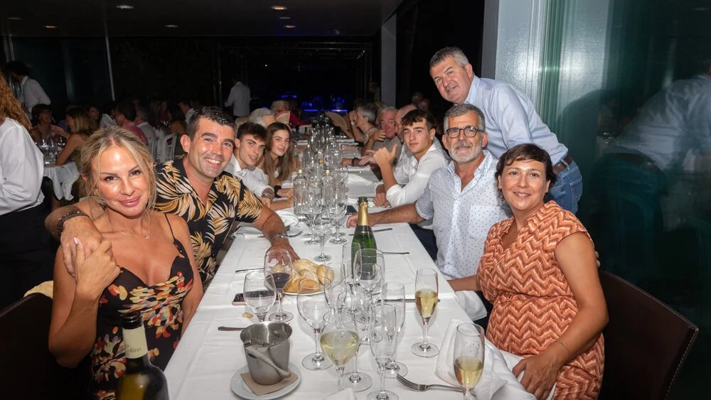 Un grupo de personas celebrando una ocasión en una mesa con comida y bebidas en un restaurante elegante