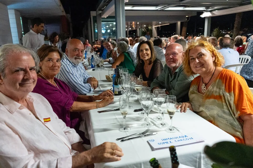 Grupo de personas sentadas en una mesa en un restaurante, disfrutando de una cena social en la noche.