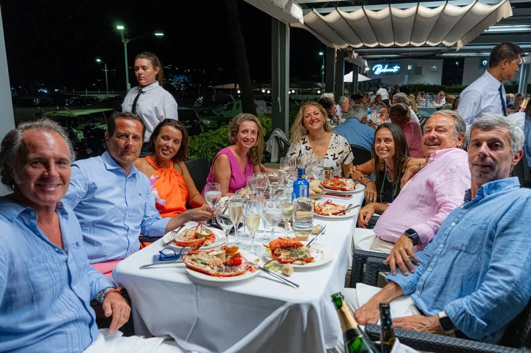 Grupo de personas en una cena al aire libre, disfrutando en un restaurante con comida de mariscos.
