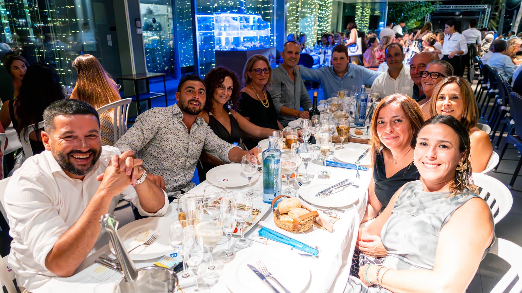 Grupo de personas en una cena elegante en un restaurante, sonriendo y disfrutando de la velada.