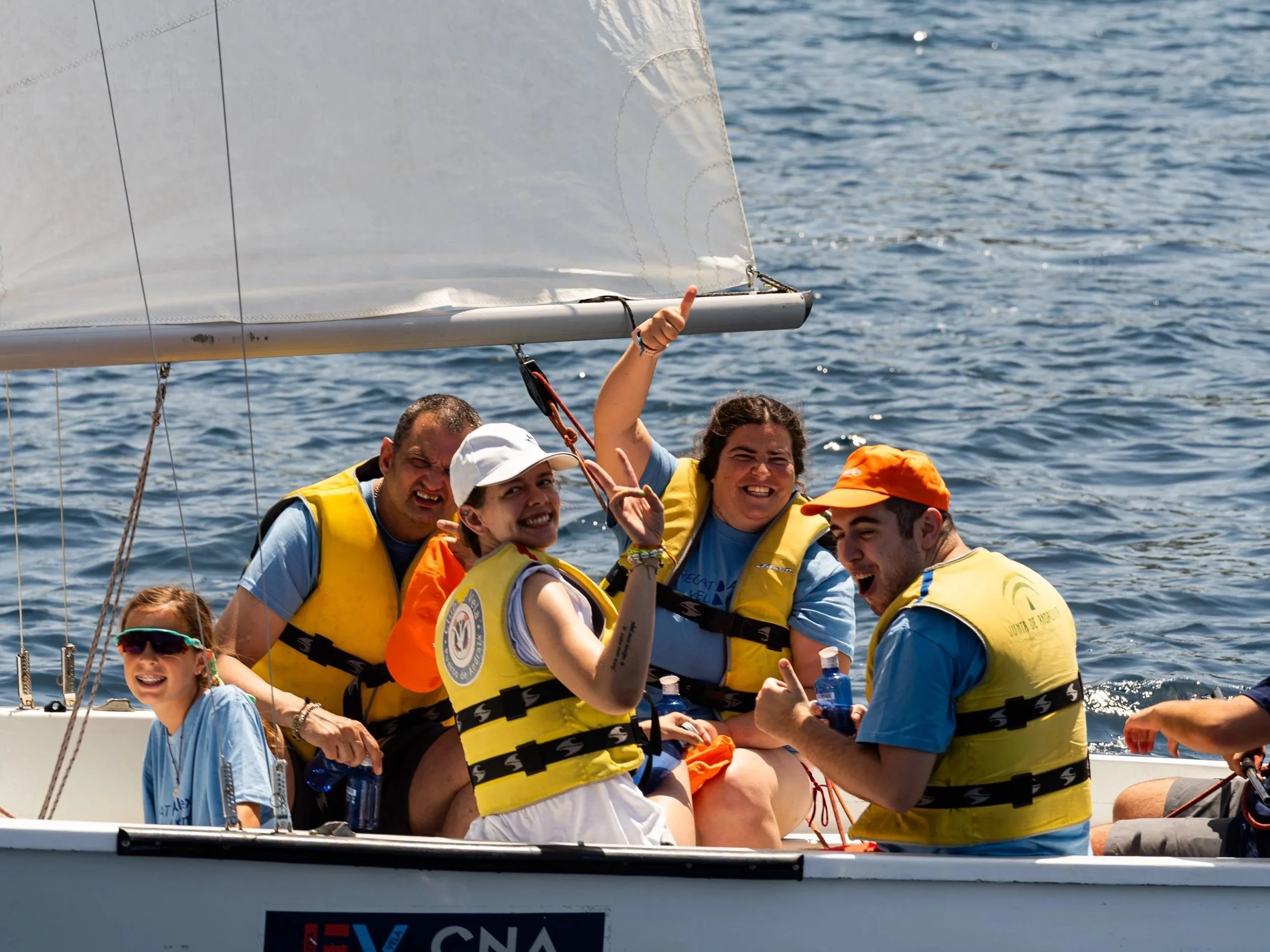 Grupo de personas en una embarcación con chalecos salvavidas, disfrutando en el agua, en un día soleado, participando en una actividad náutica o de paseo en barco.
