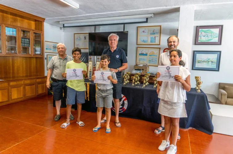 Niños y adultos en una sala recibiendo certificados y trofeos, parecería una ceremonia de premiación en un evento educativo o deportivo.