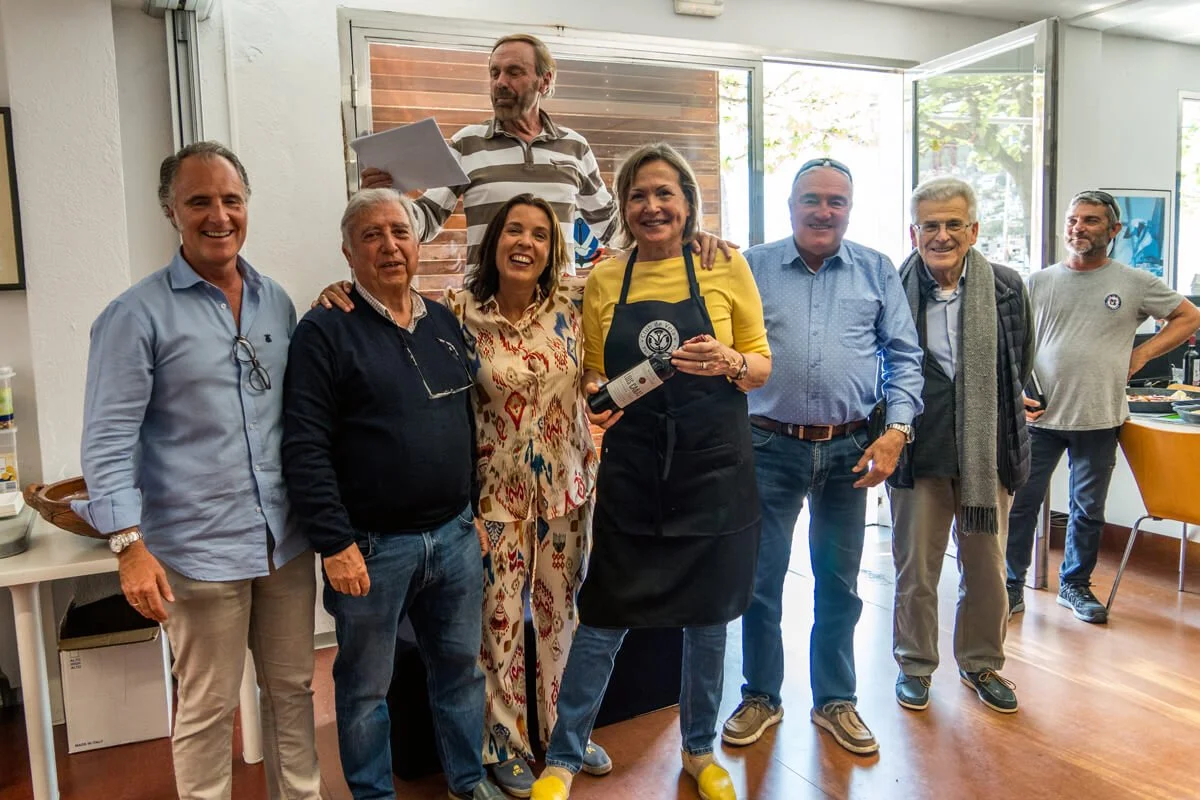 Grupo de personas sonriendo en una reunión en un interior con ventanas abiertas y decoración moderna.