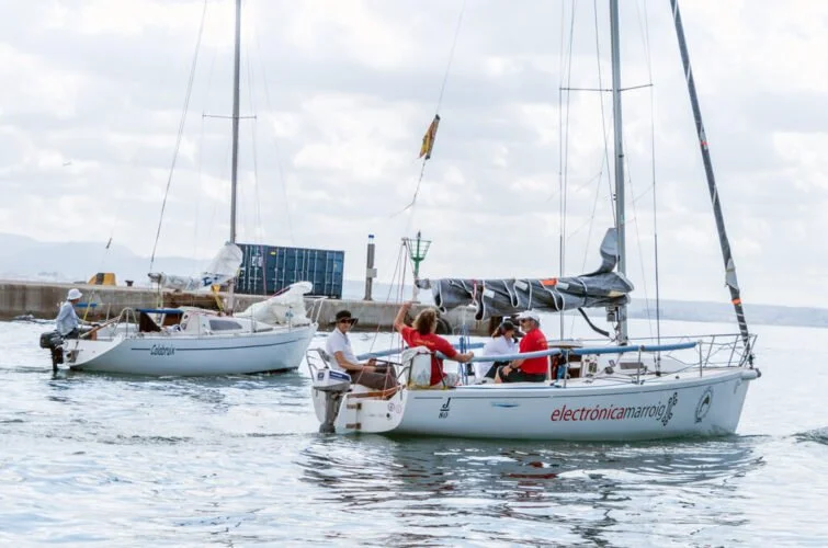Grupo de personas navegando en un velero en un día nublado en el mar.