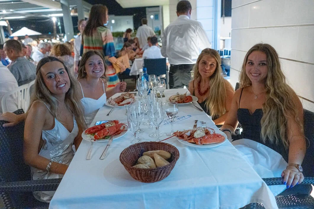 Cuatro mujeres sentadas en una mesa de restaurante disfrutando de mariscos.