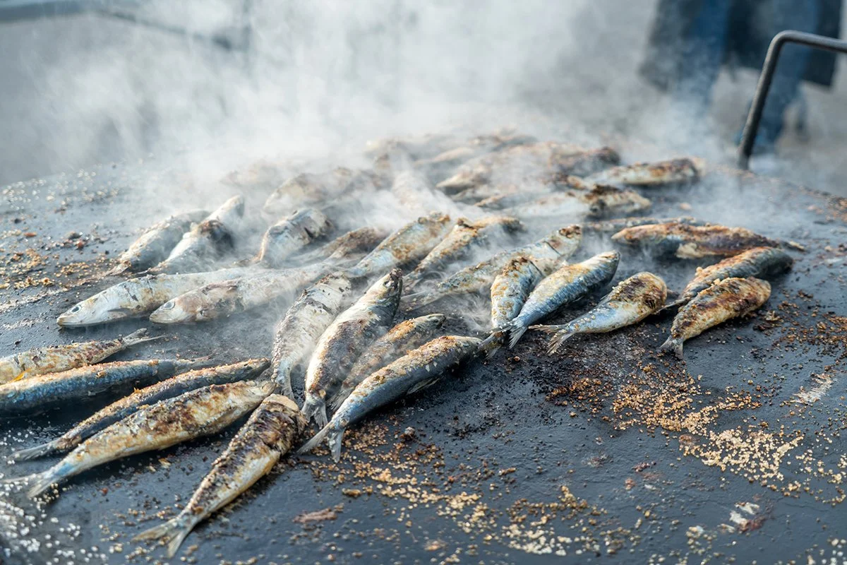 Peces asados en una parrilla con humo.
