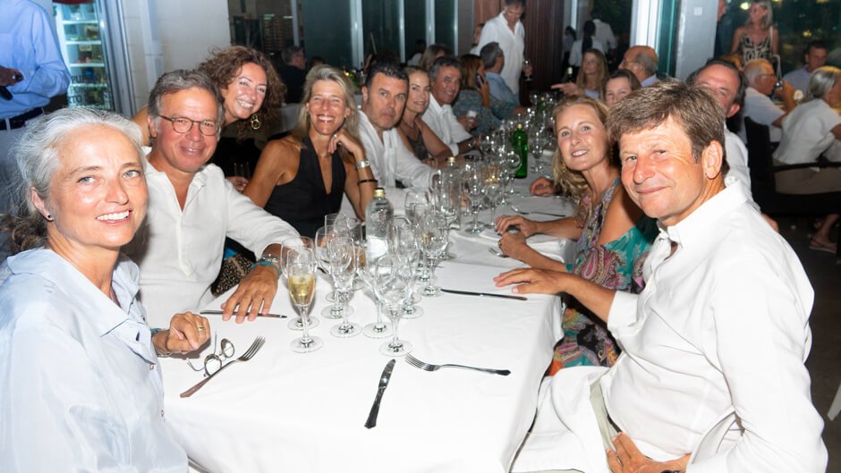 Grupo de personas sonriendo y disfrutando en una cena en un restaurante elegante.