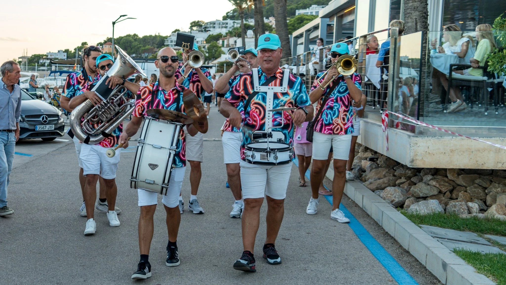 Un grupo de músicos tocando instrumentos en una calle durante una presentación en un evento al aire libre.