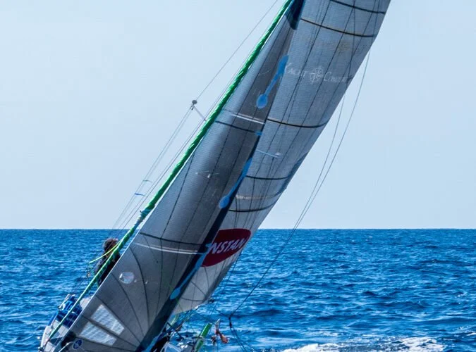 Un velero navegando en el mar con el viento inflando sus velas.