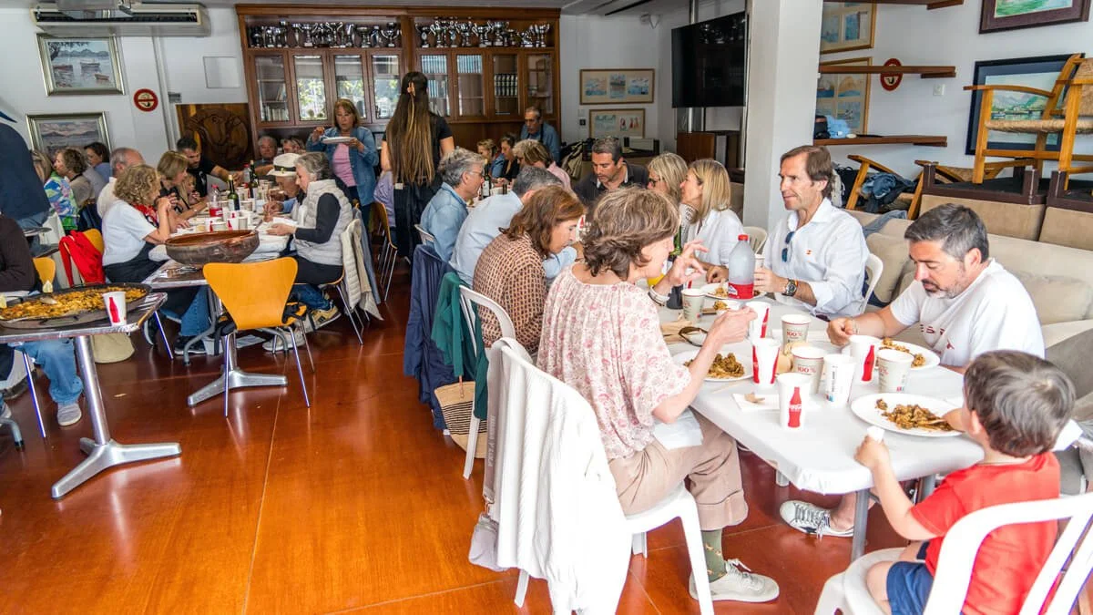Personas sentadas en mesas comiendo en un restaurante con paredes decoradas con cuadros y muebles en el fondo