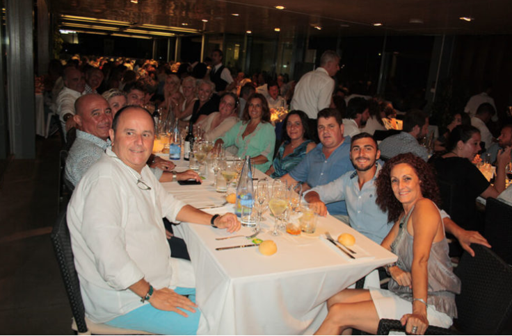 Grupo de personas sentadas en una mesa de restaurante durante una noche.