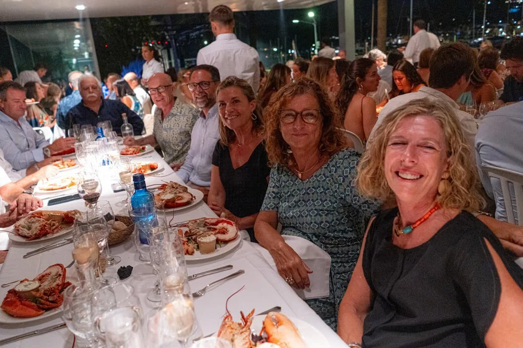 Grupo de personas disfrutando de una cena en un restaurante al aire libre por la noche.