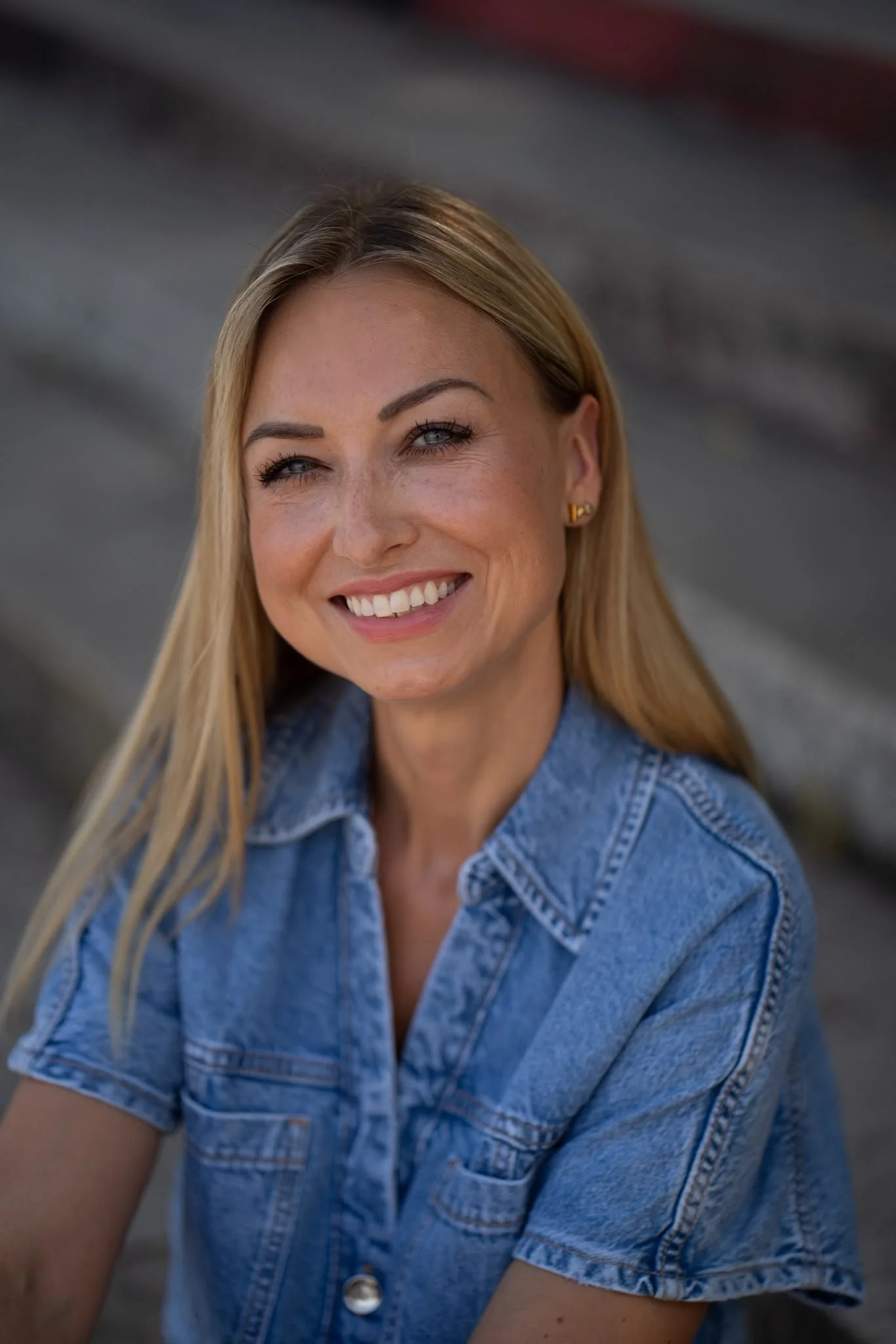 Frau mit langen blonden Haaren in Jeansbluse