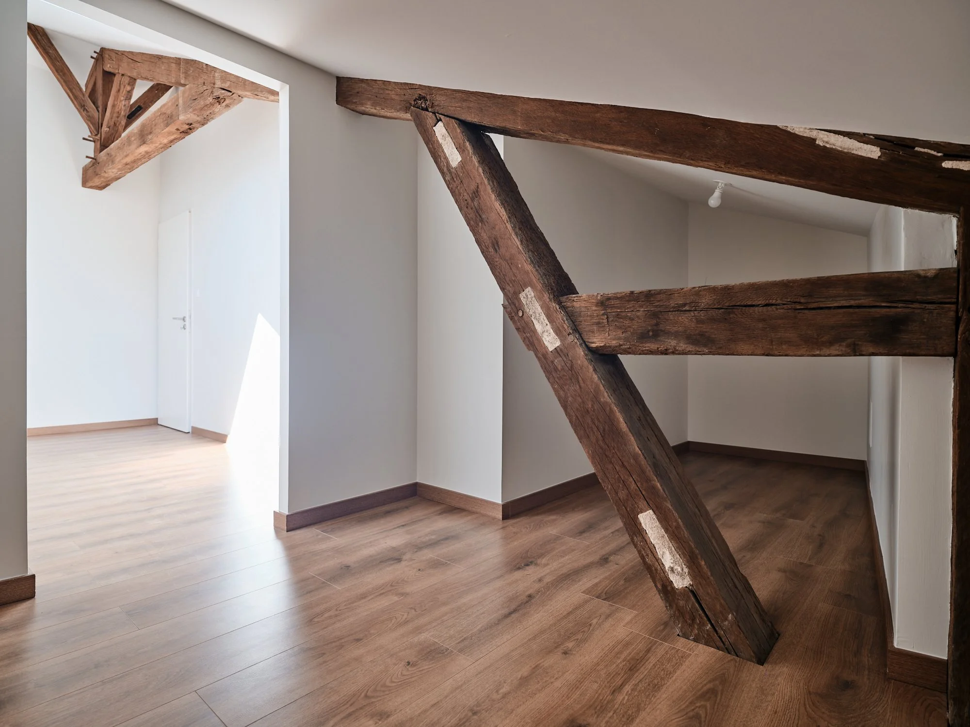 Séjour avec poutres apparentes dans un appartement rénové à Agen
