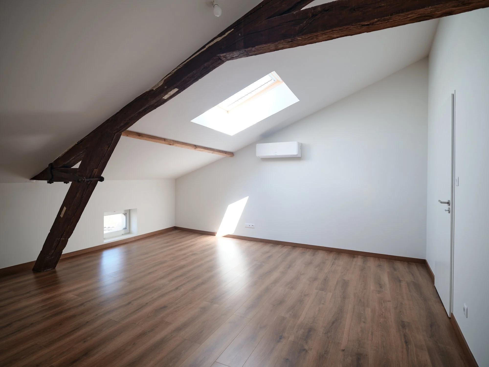 Grande pièce de vie lumineuse après rénovation des combles