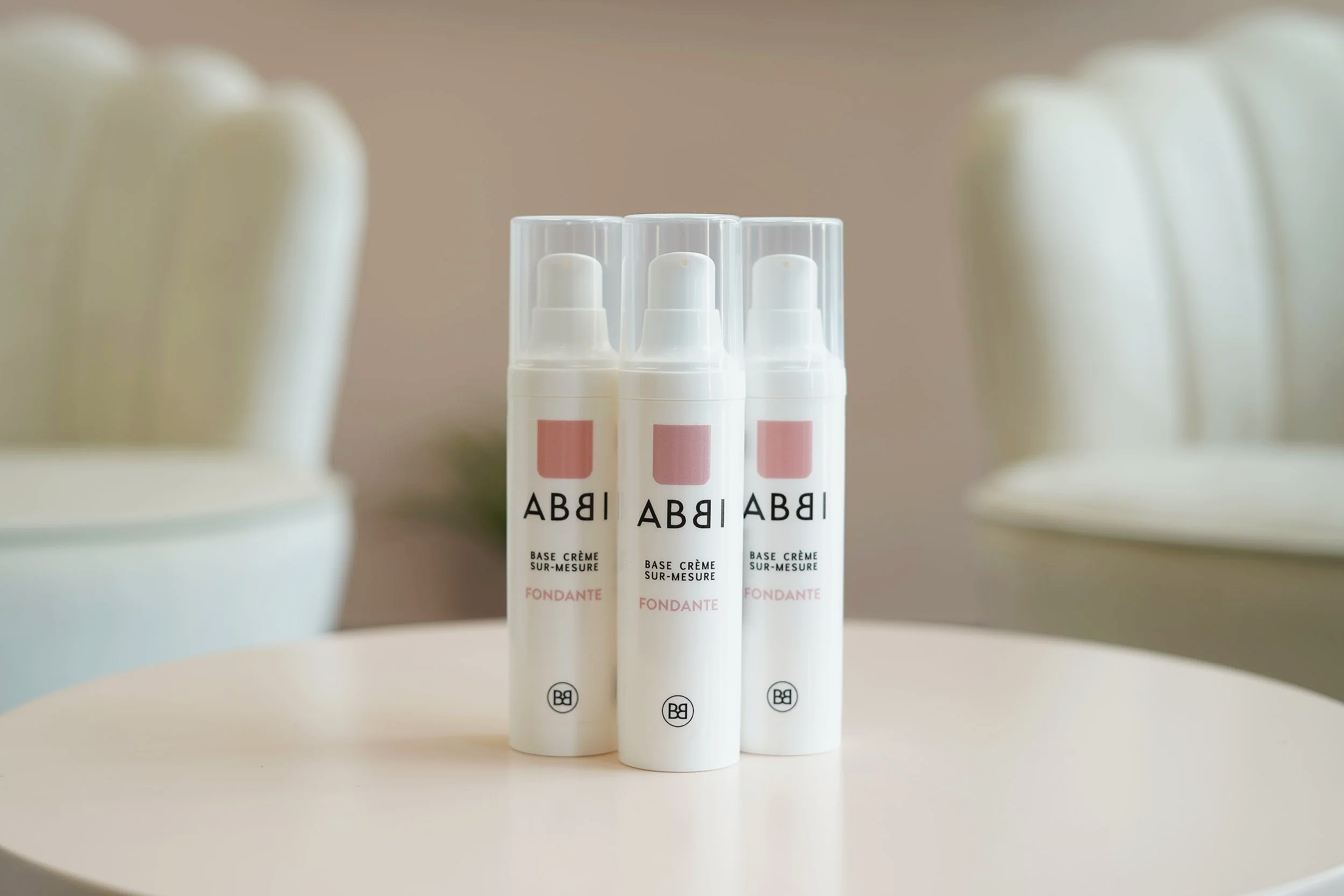 Trois tubes de base crème sur-mesure. Le texte indique qu'il s'agit d'une base crème fondante, avec un logo ABBI en bas.