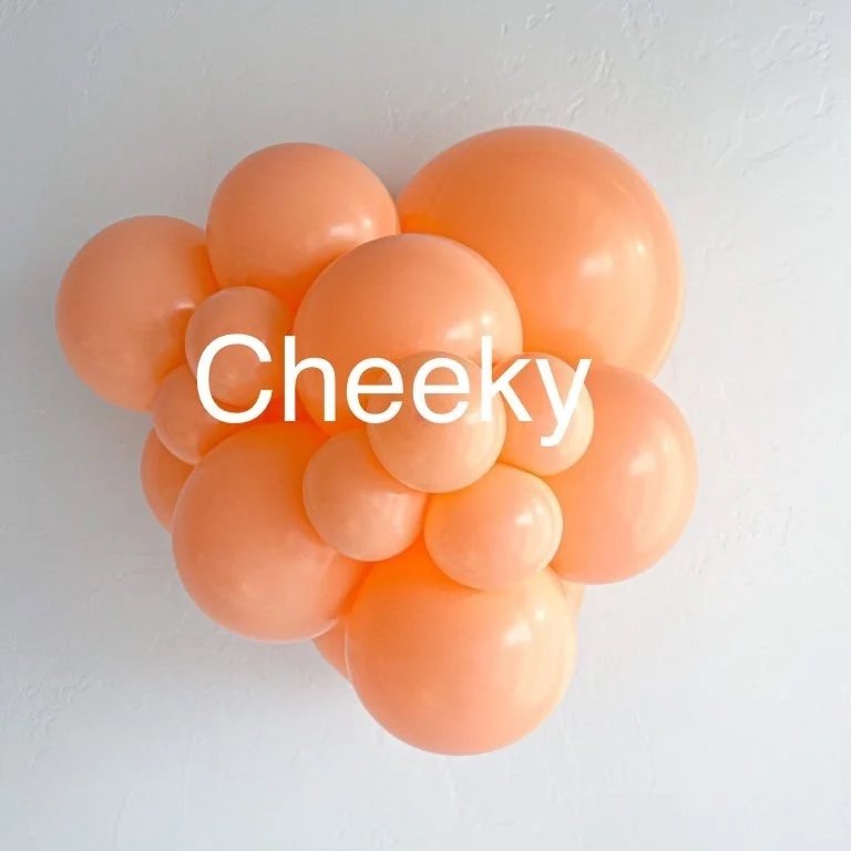 A cluster of peach-colored balloons arranged on a wall with the word "Cheeky" written across them.