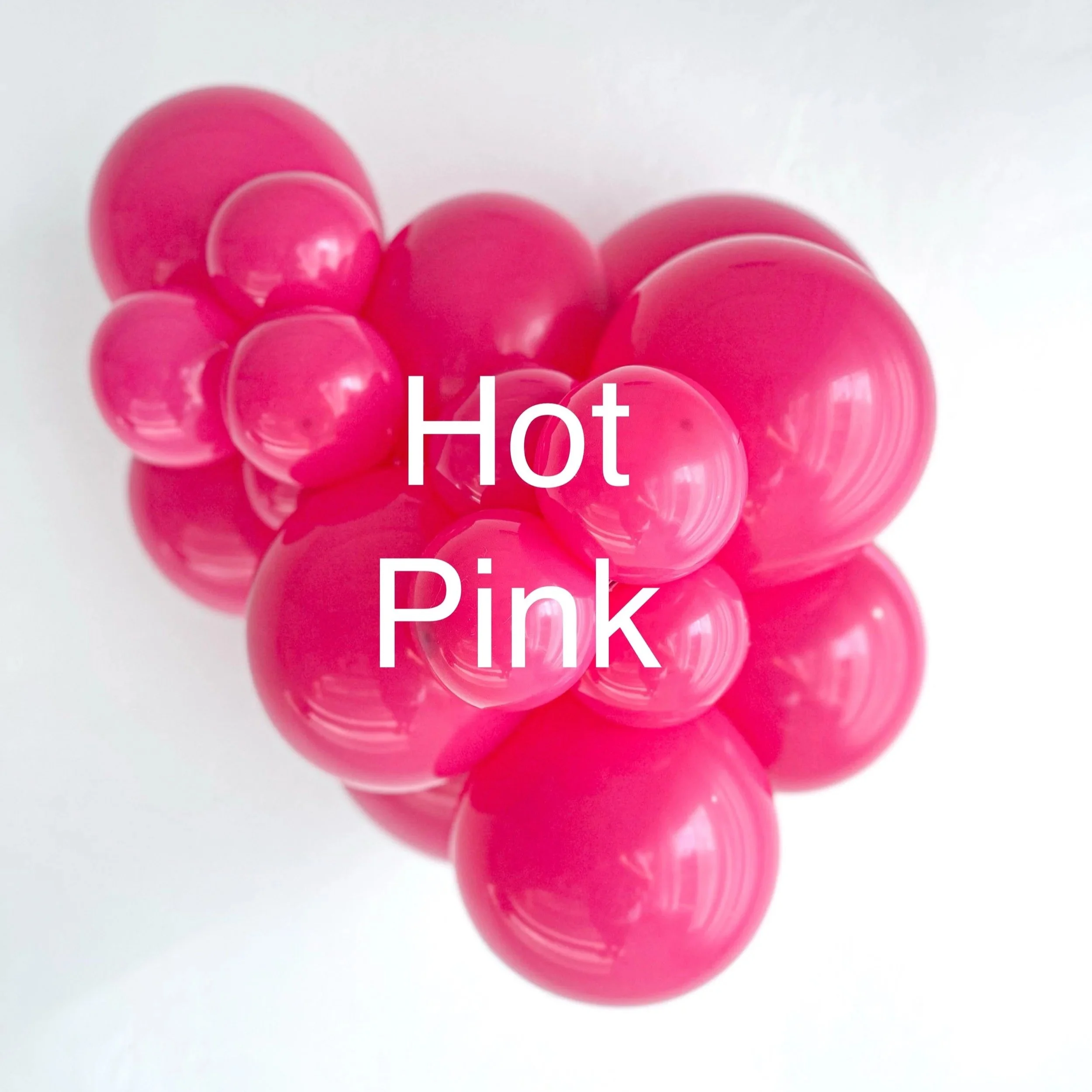 Close-up of multiple pink rubber or plastic balls clustered together on a white background.