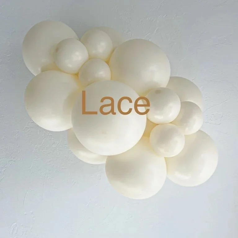 A cluster of various sized pearl-white spherical objects arranged in a decorative manner on a white ceiling