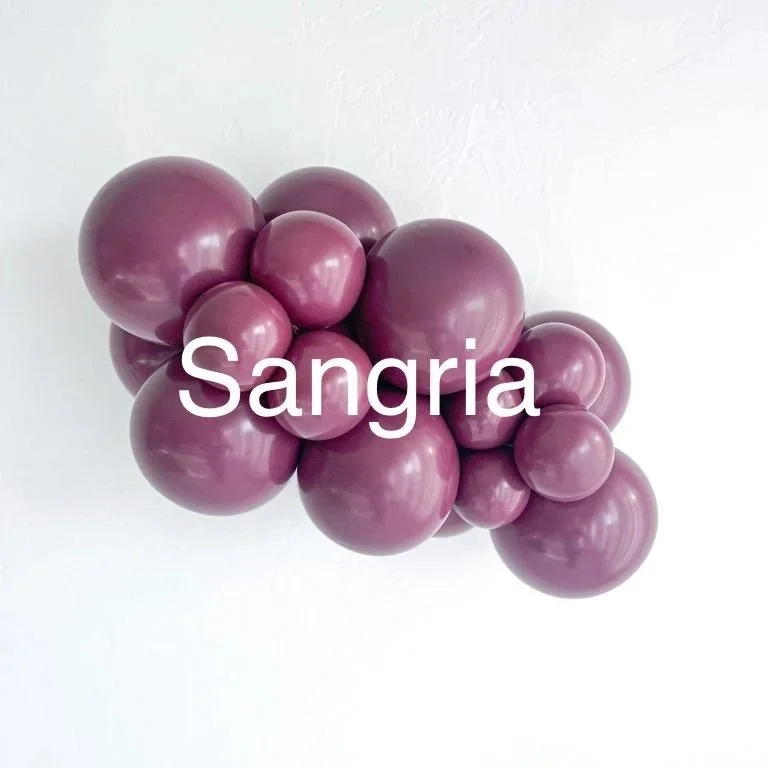 A cluster of purple grapes with the word 'Sangria' overlaid in white text.