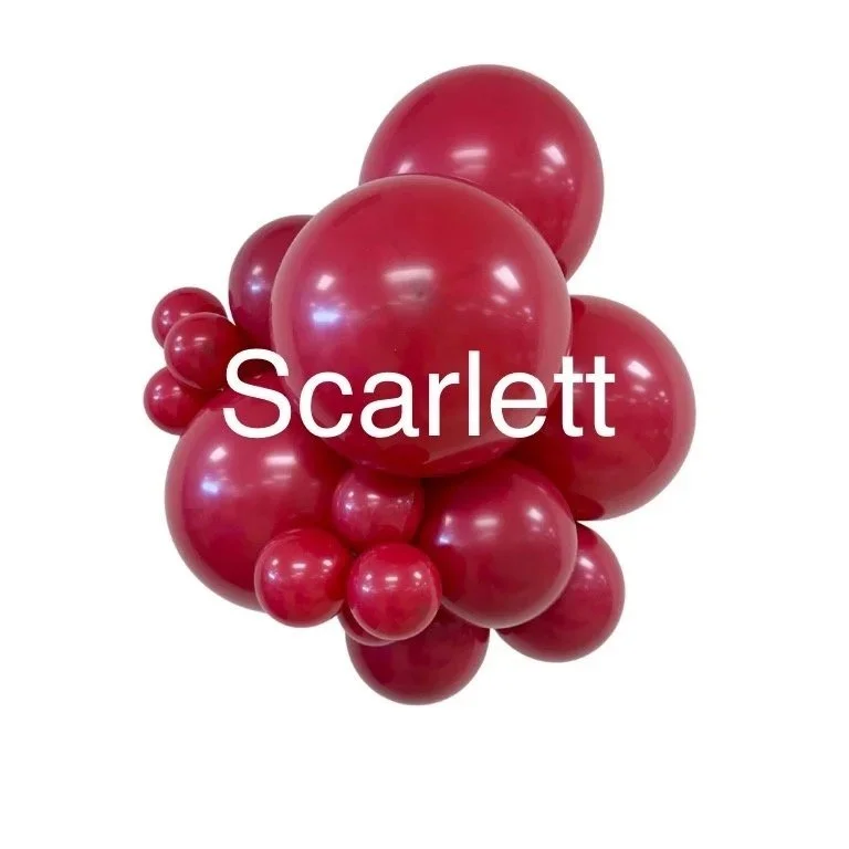 Red and pink balloons arranged in a cluster with the name "Scarlett" written across the front.