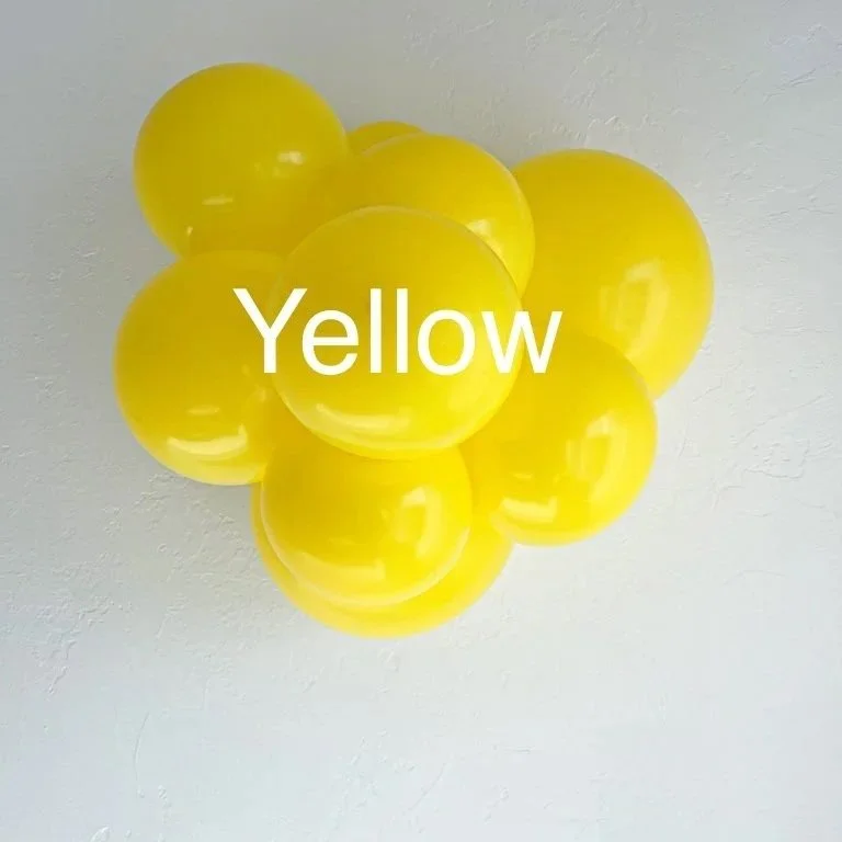 A cluster of yellow balloons attached to a ceiling with the word "Yellow" written across them.