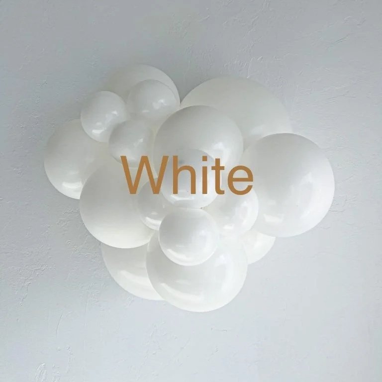 A cluster of white balloons on a light-colored ceiling with the word 'White' written in brown text overlay.