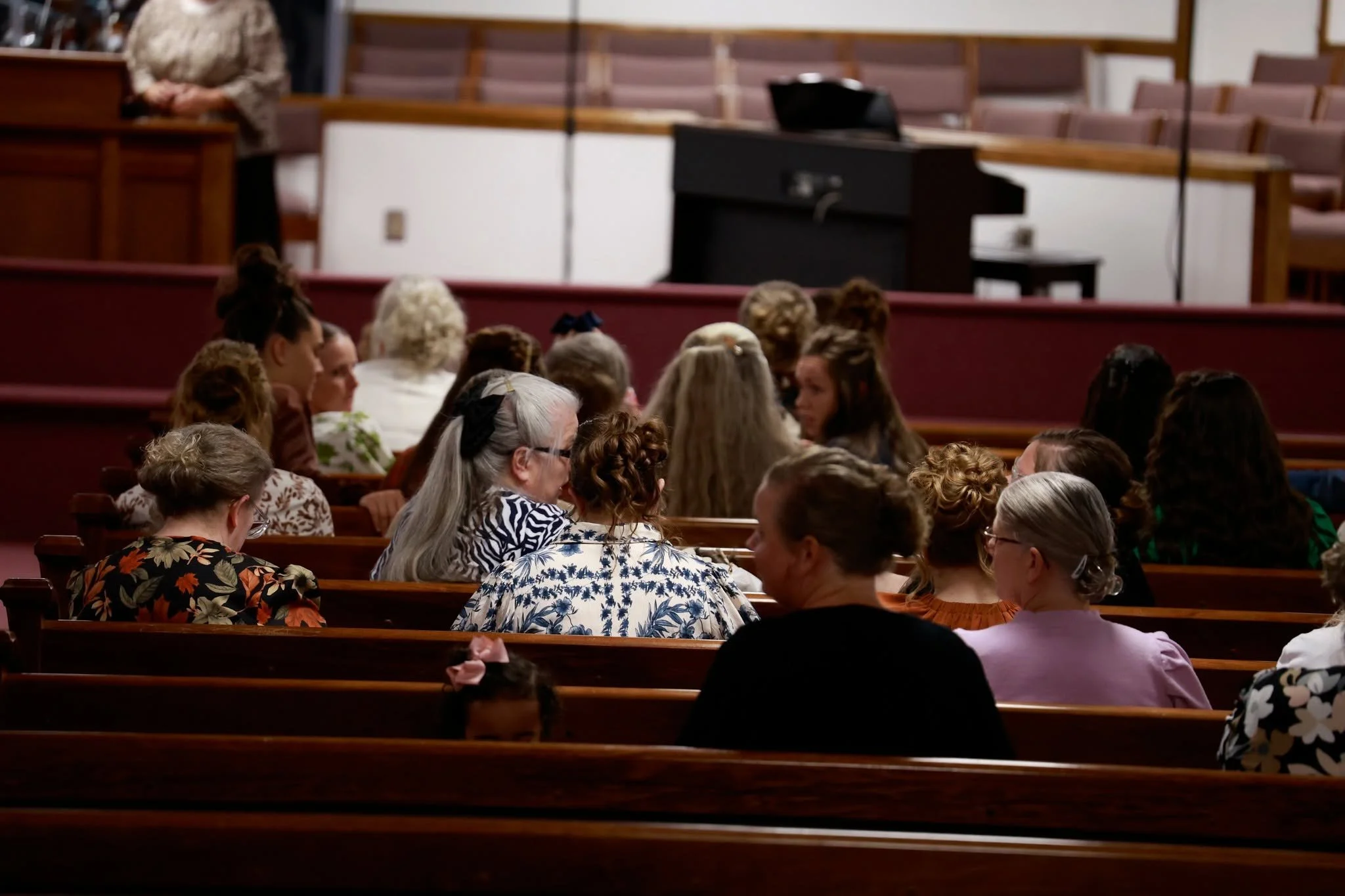 Church congregation seated on wooden pews during a service or event.