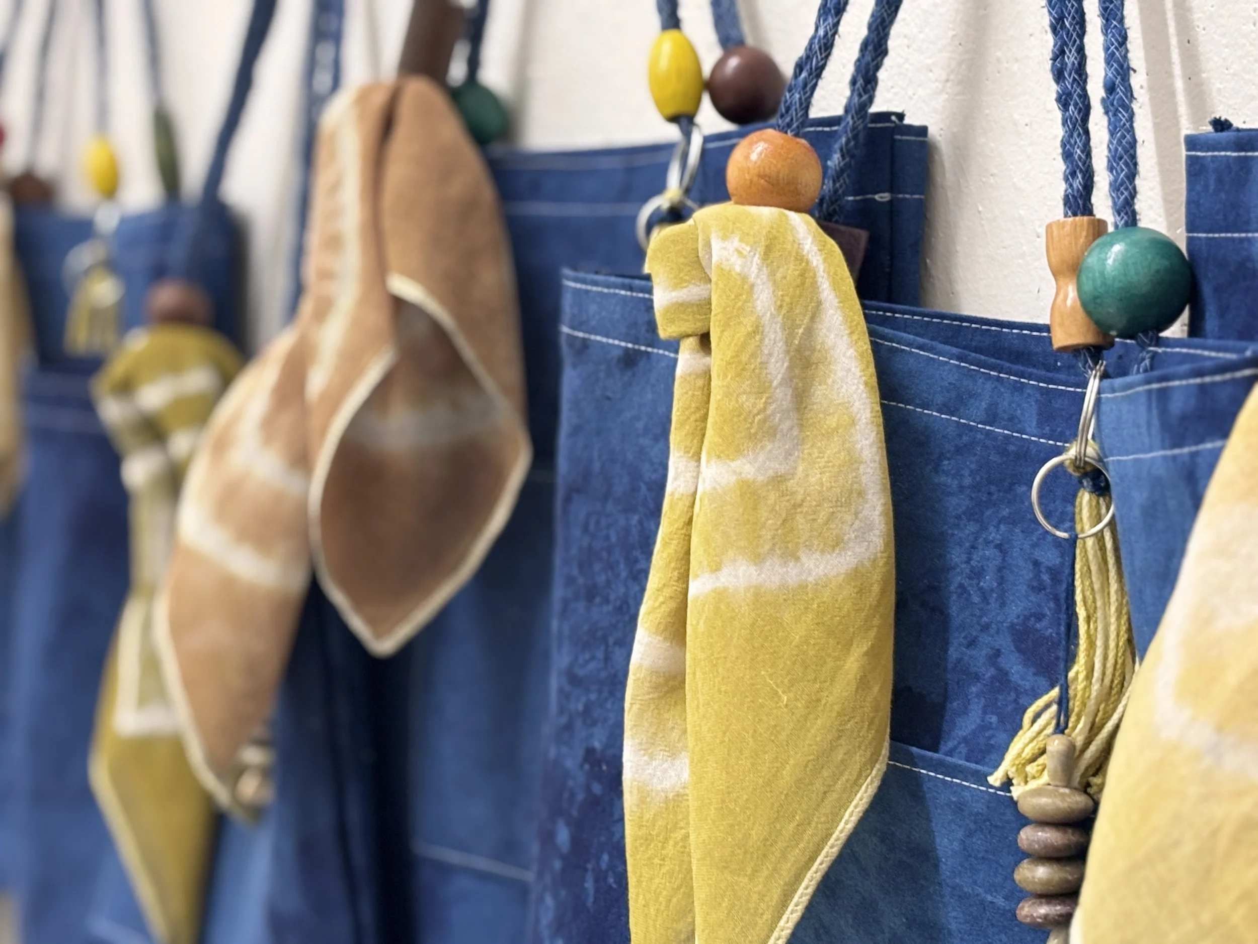 Alexis Fredericks, WORKING CLOTH., six handcrafted textile bags displayed as an installation, exploring the relationship between institutional affiliation, artistic labor, and professional recognition.